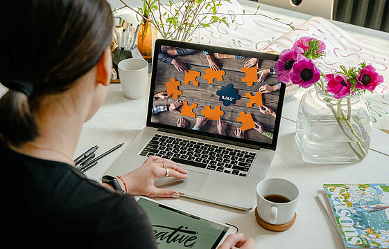Eine Frau sitzt vor einem Laptop. Auf dem Bildschrim ist eine Grafik von Ilias zu sehen.