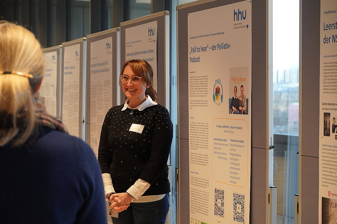Referentin vor einem Poster.